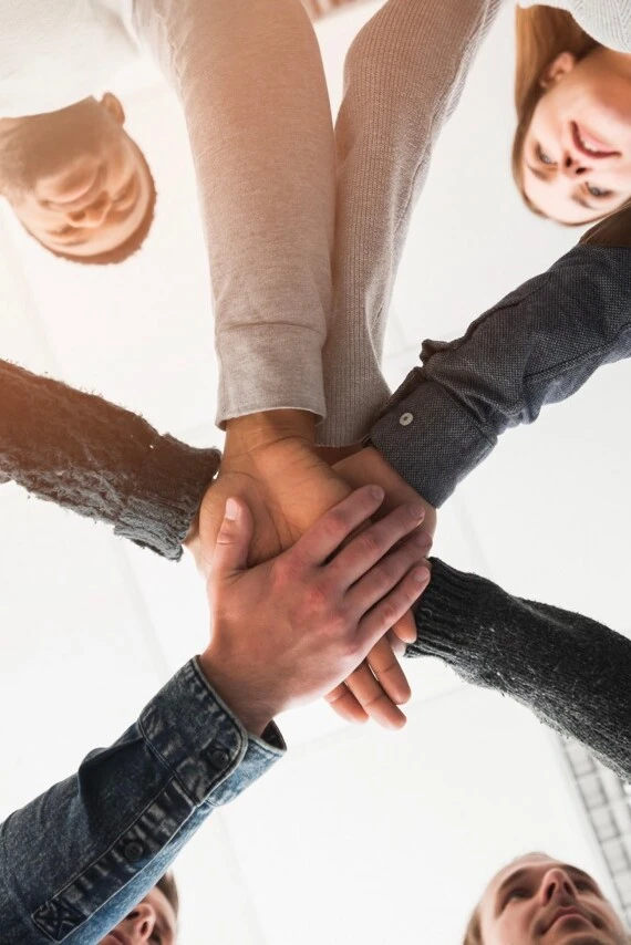 A group of people puts their hands on top of each other